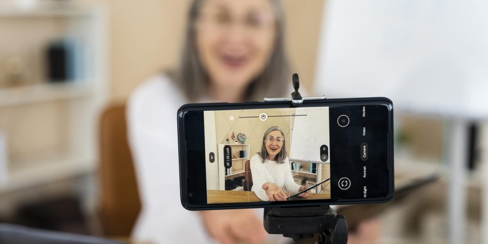 smiley-female-english-teacher-doing-online-lessons-her-smartphone